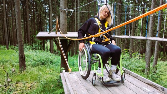 Frau im Rollstuhl beim Klettern im Abenteuerpark am Sportpark Rabenberg. Foto: Abenteuerpark 860