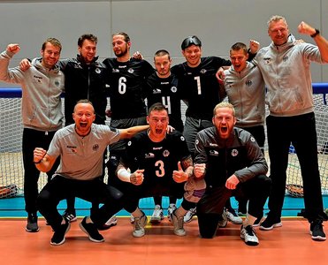 Auf dem Bild sind Deutschland Goalball-Herren zu sehen. Die hintere Reihe wurde stehend, die vordere Reihe hocken fotogarfiert. Alle jubeln freudig in die Kamera. Foto: Goalball Germany